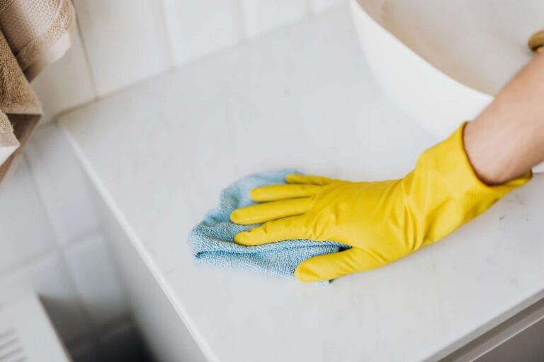 How To Clean Non Slip Flooring 8 cleaner with gloved hand cleaning the bathroom sink