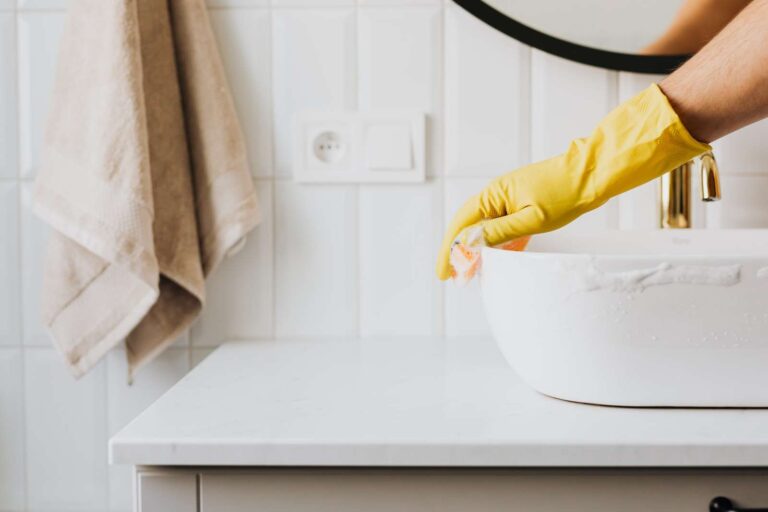 How to Clean Red Wine Stains on Leather: A Pro's Guide 7 Closeup of gloves hand cleaning bathroom sink