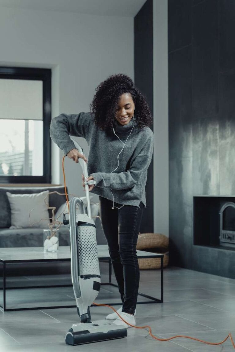 How to Clean Quarry Tile Floors Without Causing Damage 7 A Woman in Gray Sweater Using a Vacuum Cleaner