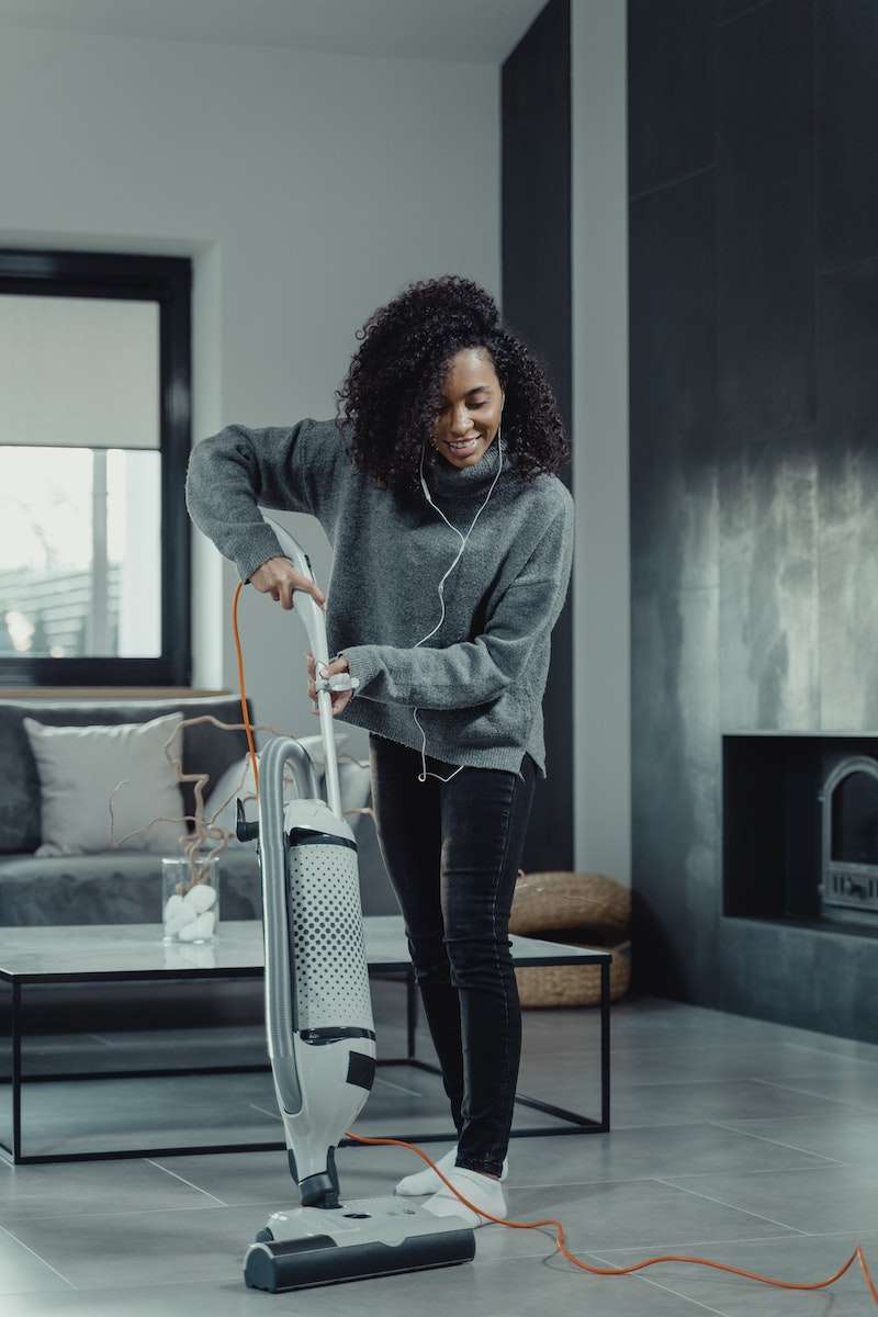 How to Clean Quarry Tile Floors Without Causing Damage 1 A Woman in Gray Sweater Using a Vacuum Cleaner