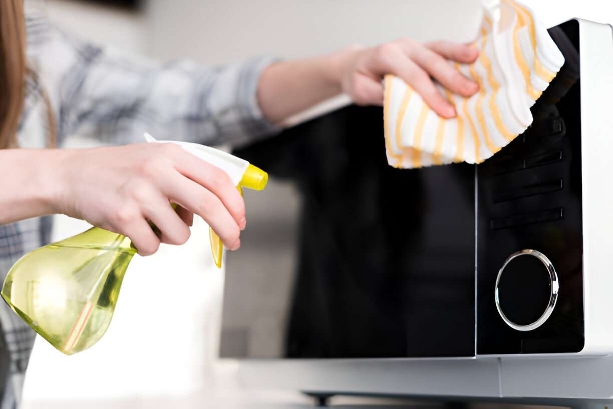 How to Clean a Microwave With Vinegar Like a Pro 1 woman cleaning the microwave