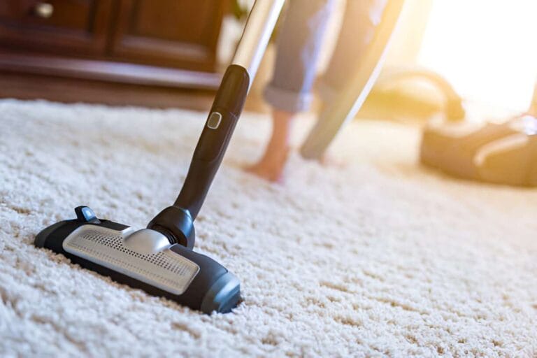 How to Clean a Wool Rug Without Damaging It 3 person vacuuming a wool rug