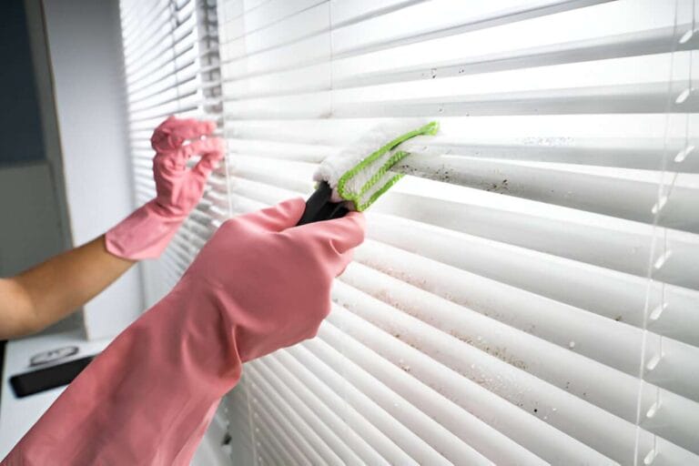 Step-by-Step Guide to Cleaning Mould Off Roller Blinds 3 close up view of gloved hands cleaning the blinds