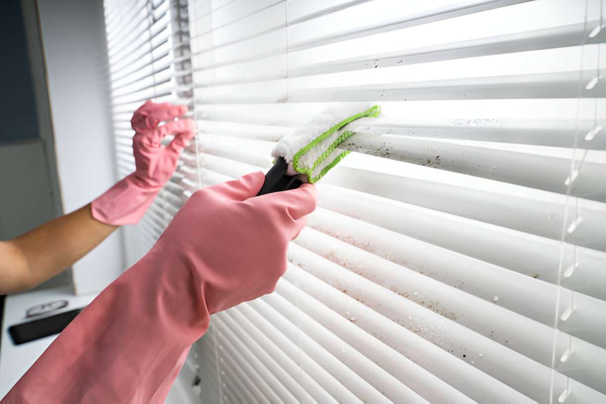 Step-by-Step Guide to Cleaning Mould Off Roller Blinds 1 close up view of gloved hands cleaning the blinds